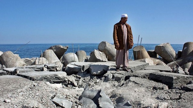 A Libyan man stands on Sirte’s bombed fishing harbour 640
