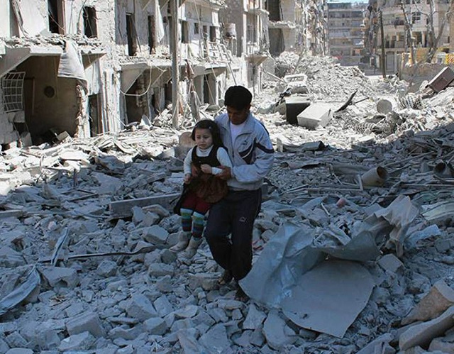 A Syrian man carries a girl amidst the rubble of houses in Aleppo, Syria [Source: AP]