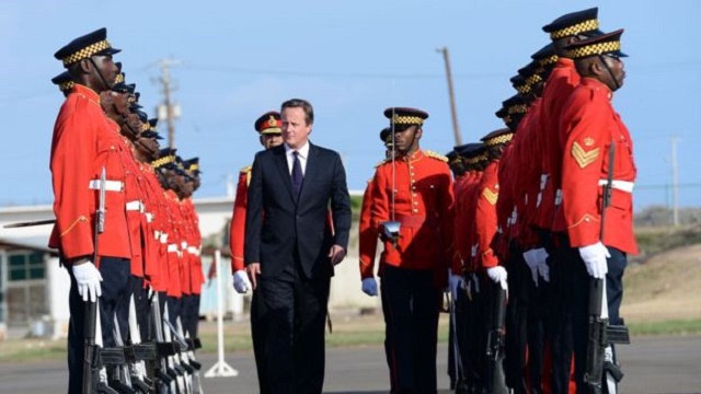David Cameron greeted by an honour guard at the airport in Kingston. (Source: PA)