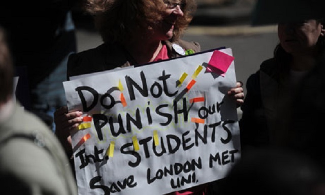 A protester holds a placard outside the Home Office in central London following the government's decision to strip London Metropolitan University of its right to sponsor visas for overseas students. (Photograph: Carl Court/AFP/Getty Images)